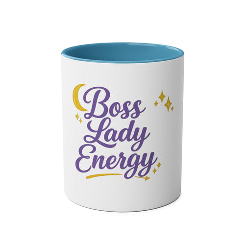 A white ceramic mug with a light blue interior, featuring the phrase 'Boss Lady Energy' printed in purple script with yellow crescent moon and star accents on the front, set against a plain white background.